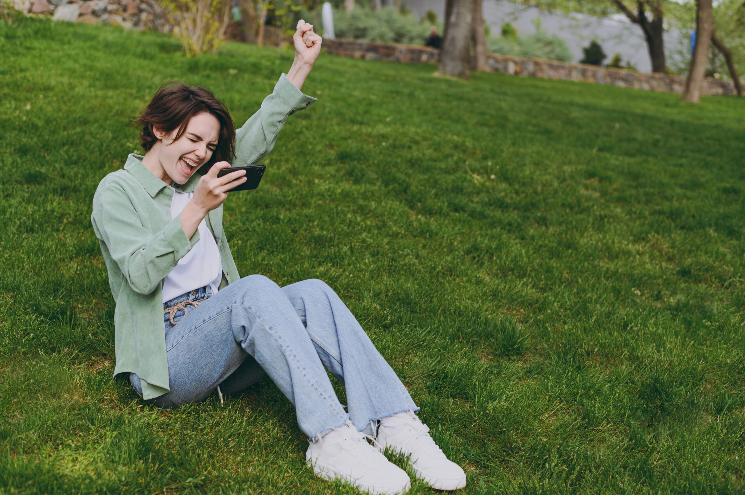 Young,Woman,In,Green,Jacket,Jeans,Sit,On,Grass,In